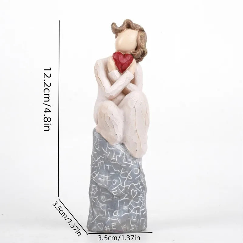 A girl sitting and holding a heart Valentine’s Day gift