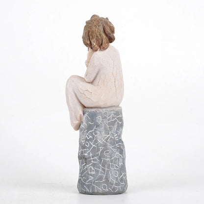 A girl sitting and holding a heart Valentine’s Day gift