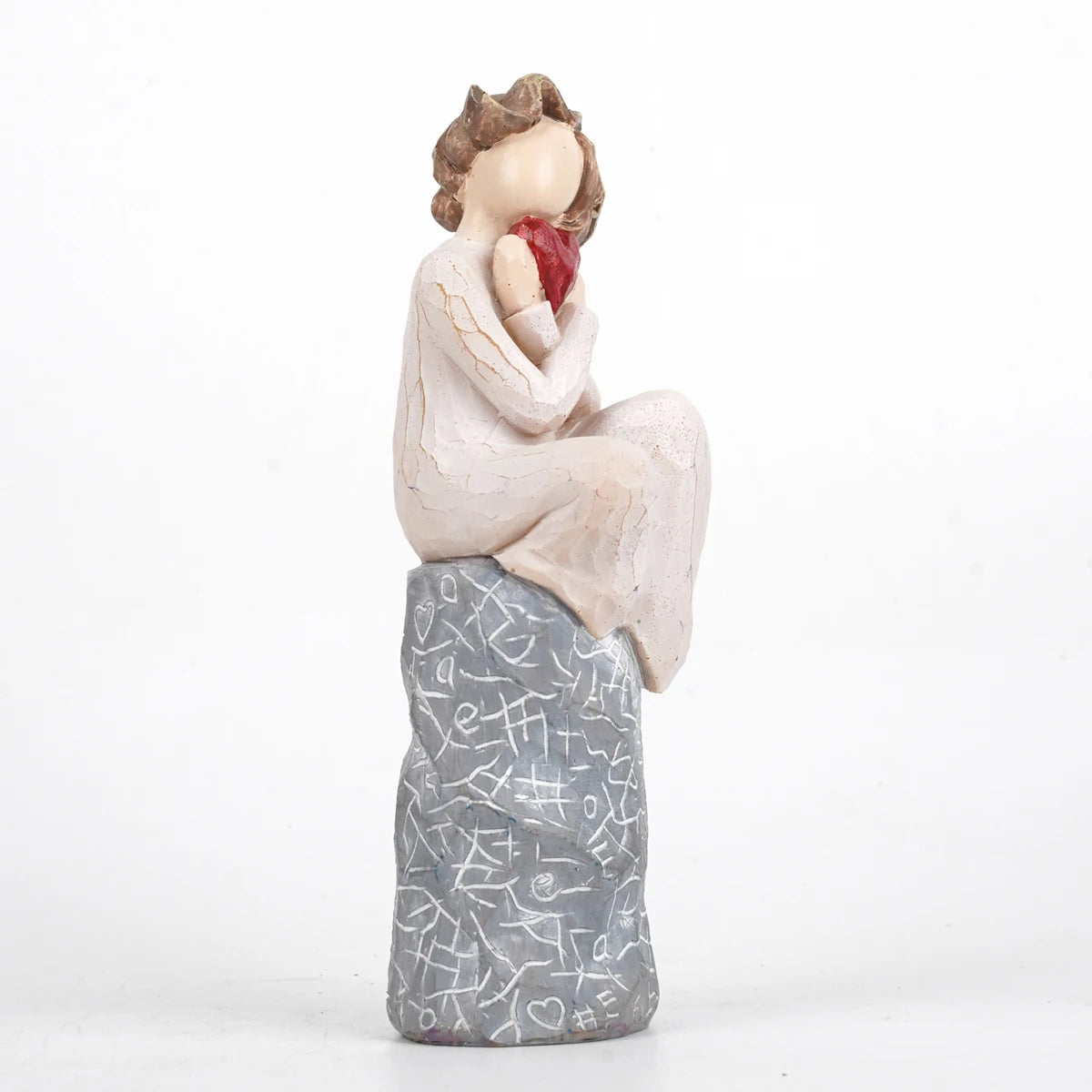 A girl sitting and holding a heart Valentine’s Day gift